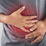 Uomo con le mani sulla pancia in posizione dolorante e un disegno in sovraimpressione dell'intestino su sfondo rosso