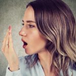 Donna con una mano davanti alla bocca